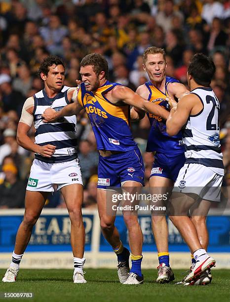 Steven Motlop and Mathew Stokes of the Cats wrestle with Jacob Brennan and Adam Selwood of the Eagles during the round 20 AFL match between the West...