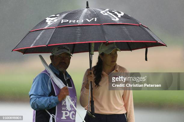 Daniela Darquea of Ecuador stands under an umbrella with her caddie on the fourth hole during the second round of the KPMG Women's PGA Championship...