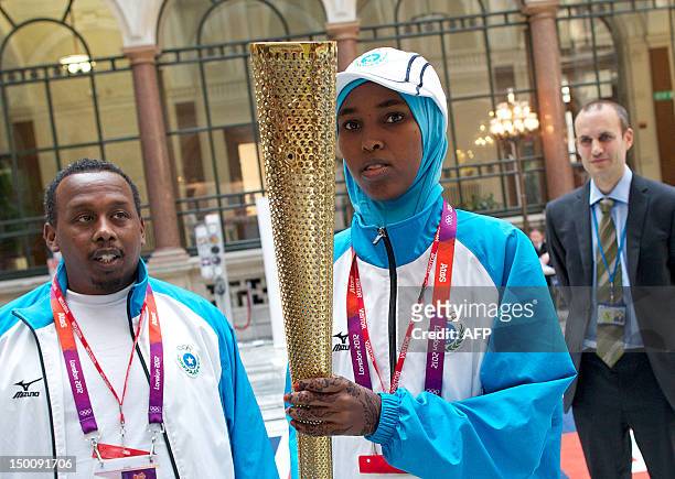 Somali athlete Zamzam Mohamed Farah poses for pictures with a London 2012 Olympic Torch during a visit to to the Foreign and Commonwealth Office in...