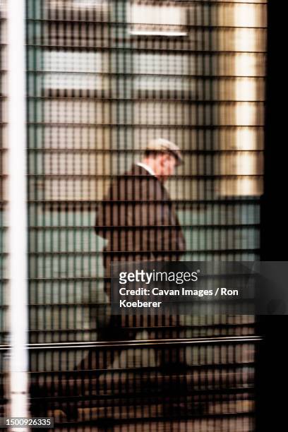 man walking behind fence - koeberer stock pictures, royalty-free photos & images