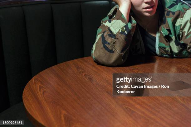 a woman leaning on a table - koeberer stock pictures, royalty-free photos & images