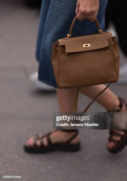 Fashion Week guest is seen wearing Celine brown leather sandals and beige leather Hermes Kelly bag outside Givenchy during the Menswear Spring/Summer...