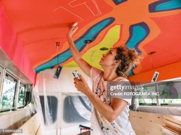 mid adult iranian woman artist painting  mural inside party bus - party bus bildbanksfoton och bilder