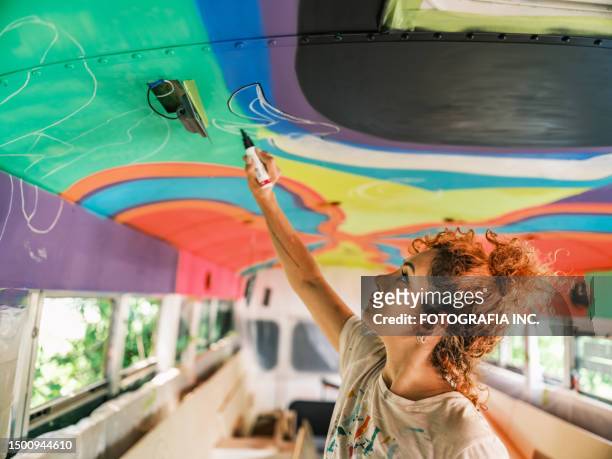 mid adult iranian woman artist painting  mural inside party bus - party bus stock pictures, royalty-free photos & images