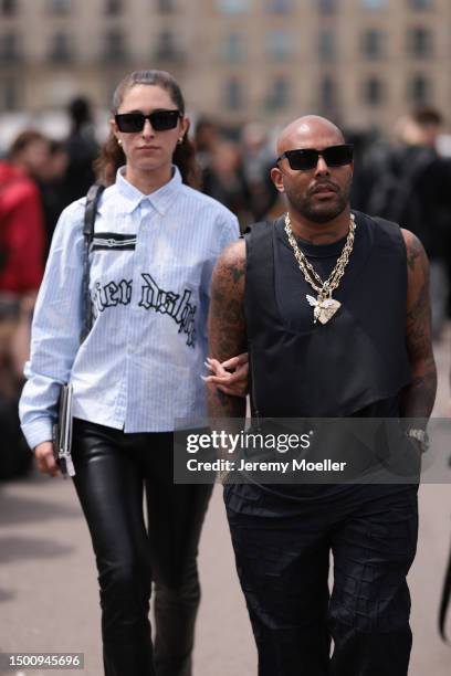 Fashion Week guest is seen striped light blue flanell shirt and black leather leggings outside Givenchy during the Menswear Spring/Summer 2024 as...