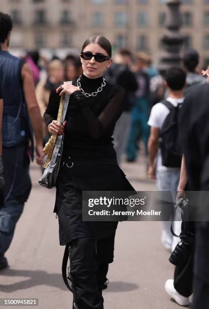 Fashion Week guest is seen wearing two Givenchy bags a silver and gold one, black mesh top, black tank top, black skirt and black destroyed jeans...