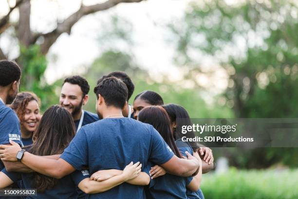 grupo diverso se reúne para revisar el día - caridad y auxilio fotografías e imágenes de stock