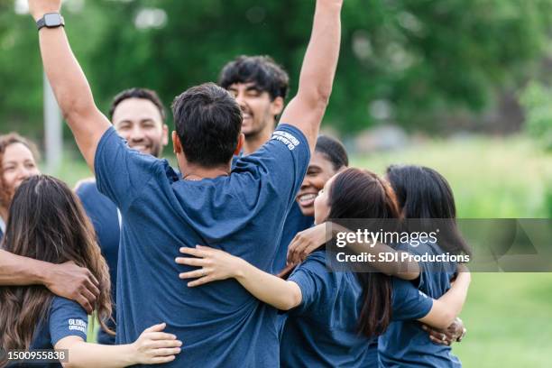 diverse team cheers successful day of meeting objectives - team building imagens e fotografias de stock