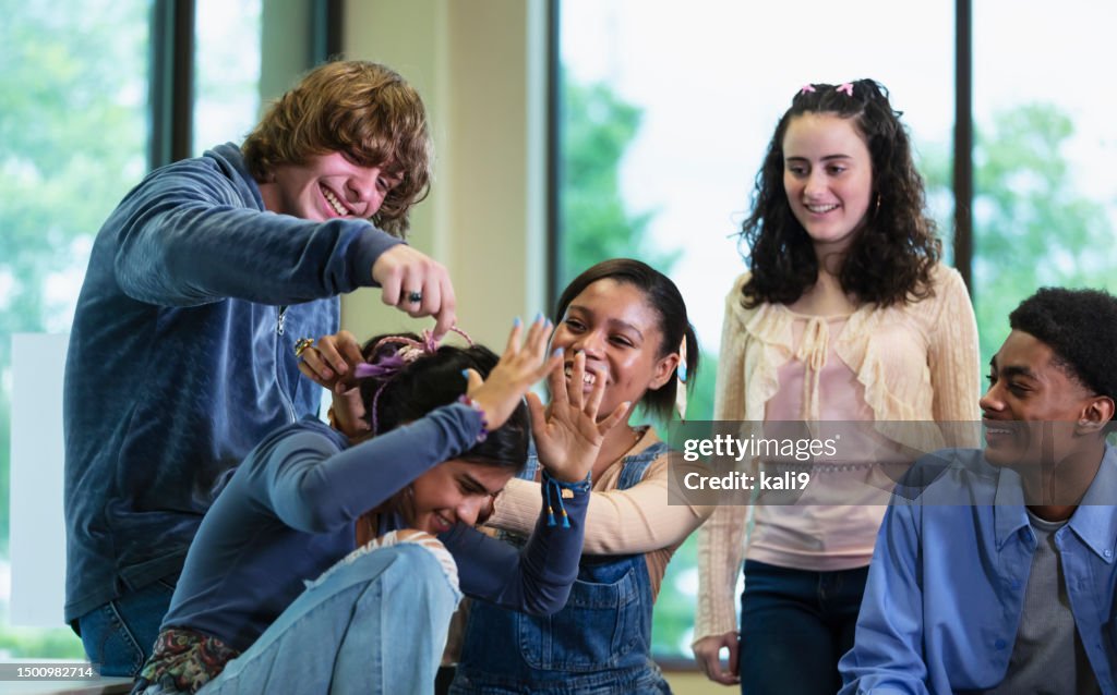 Multiracial group of teenagers, playfully teasing friend