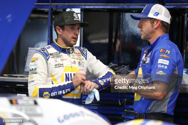 Chase Elliott, driver of the NAPA Auto Parts Chevrolet, and crew chief Alan Gustafson talk in the garage area during practice for the NASCAR Cup...