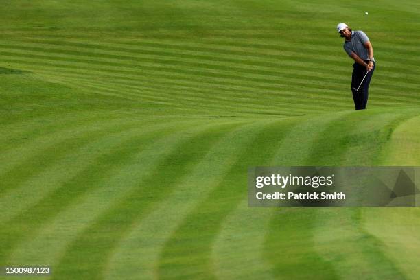 Tommy Fleetwood of England chips on the 15th green during the first round of the Travelers Championship at TPC River Highlands on June 22, 2023 in...
