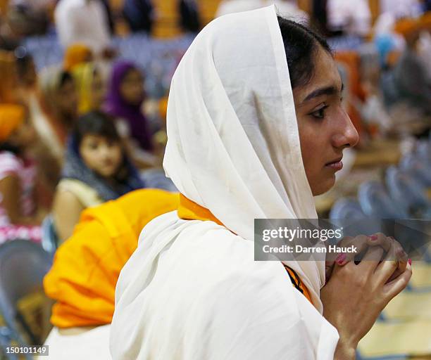 Woman looks on as family, friends and community members pay respects to the six victims in the mass shooting at the Sikh Temple of Wisconsin at the...