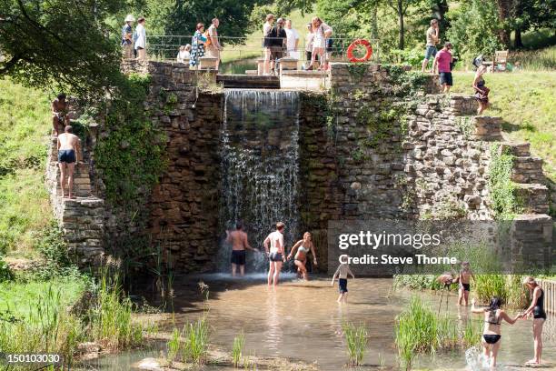 The crowd enjoying the lake and waterfall during the Wilderness Festival at Cornbury Park on August 10, 2012 in Oxford, United Kingdom.