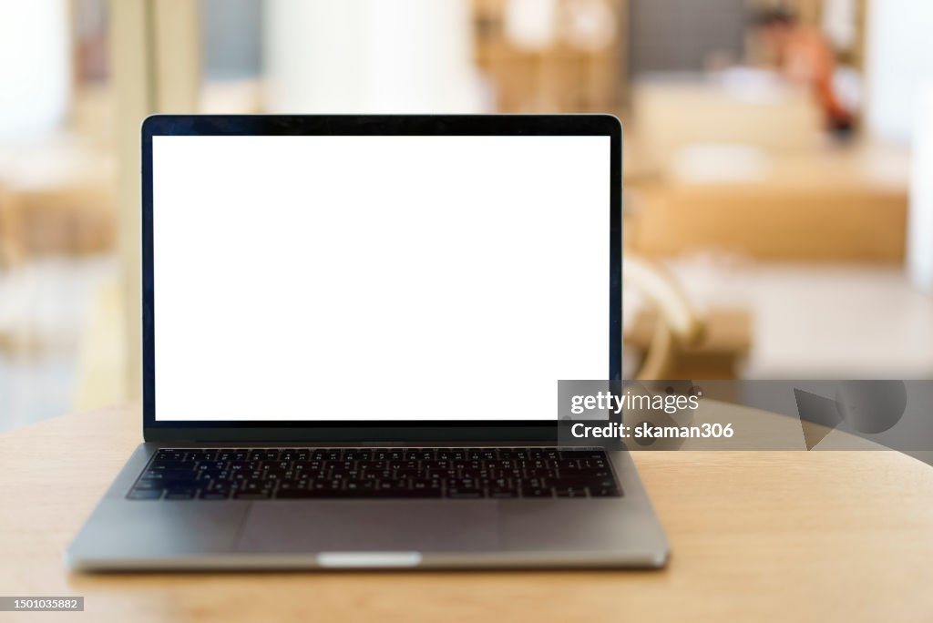 Closeup blank screen laptop computer and coffee on wooden table and copyspace