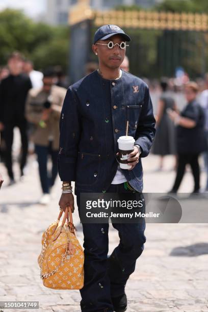 Pharrell Williams is seen wearing a Louis Vuitton denim set, Louis Vuitton cup, Tiffany & Co diamond shades and Louis Vuitton yellow croco leather...