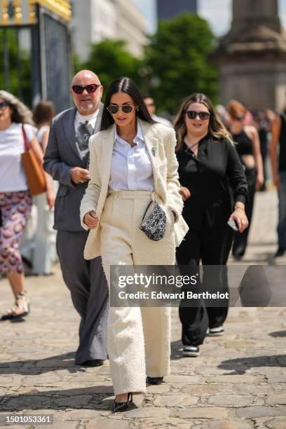 Demi Moore wears black aviator sunglasses, silver large earrings, a gold chain necklace, a white shirt, a white latte fluffy tweed blazer jacket from...