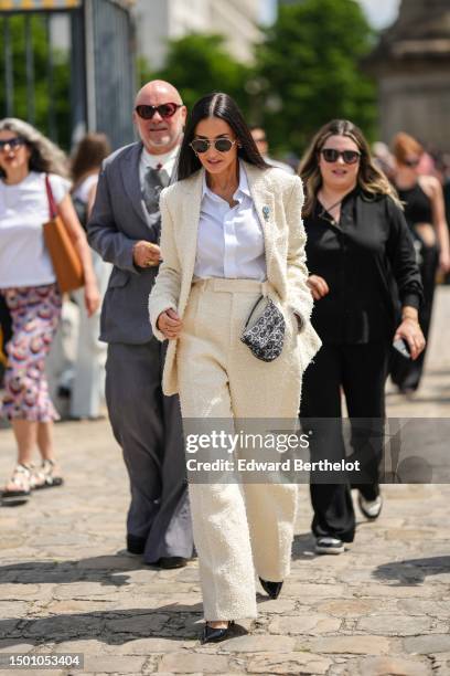 Demi Moore wears black aviator sunglasses, silver large earrings, a gold chain necklace, a white shirt, a white latte fluffy tweed blazer jacket from...