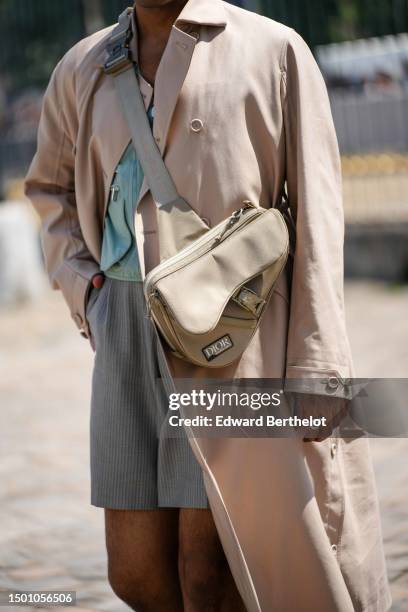 Rahi Chadda wears a pale green with pale gray borders cargo shirt from Dior, a beige long coat, a beige fabric crossbody Saddle clutch from Dior,...