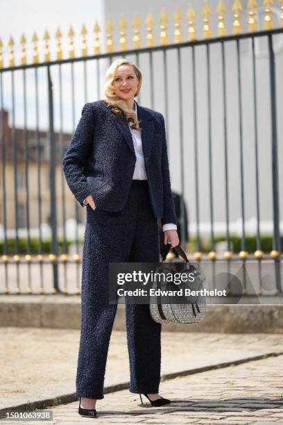 Gwendoline Christie wears a white shirt, a navy blue tweed fluffy blazer jacket from Dior, matching navy blue tweed fluffy large suit pants from...