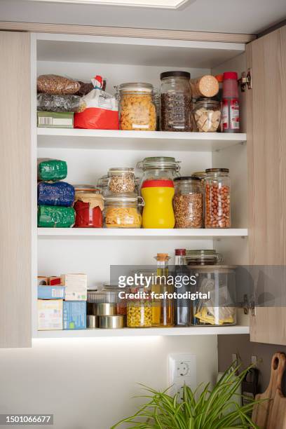 open kitchen cabinet full of groceries - cabinet door stock pictures, royalty-free photos & images