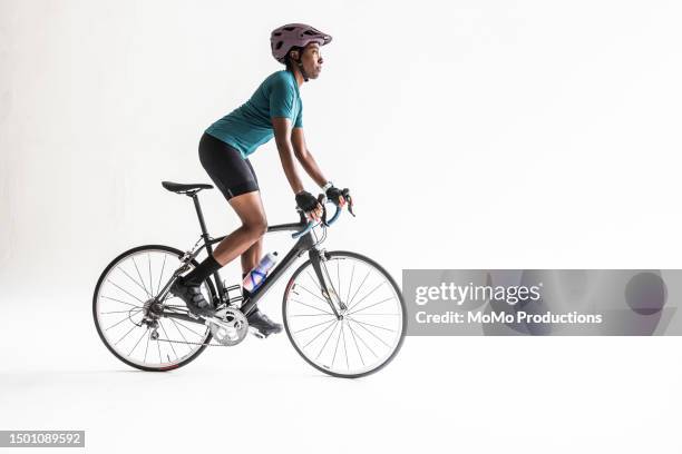 studio image of young male cyclist pedaling on white background - black shorts stock pictures, royalty-free photos & images