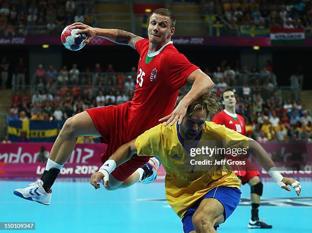 Szabolcs Zubai of Hungary shoots over Magnus Jernemyr of Sweden during the Men's Handball semifinal game between Hungary and Sweden on Day 14 of the...