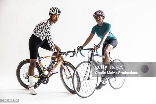 studio portrait of young cyclists on white background - cyclo photos et images de collection
