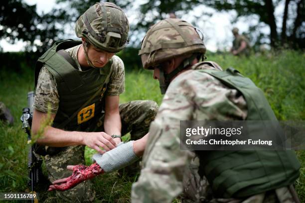 Ukrainian combat medic Mike administers first aid to an exercise casualty during the first combat medical training course in the UK to Ukrainian...