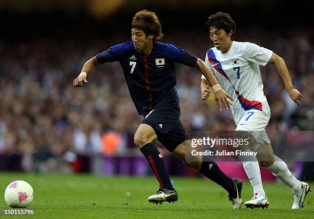 Yuki Otsu of Japan goes past Bokyung Kim of Korea during the Men's Football Bronze medal play-off match between Korea and Japan on Day 14 of the...