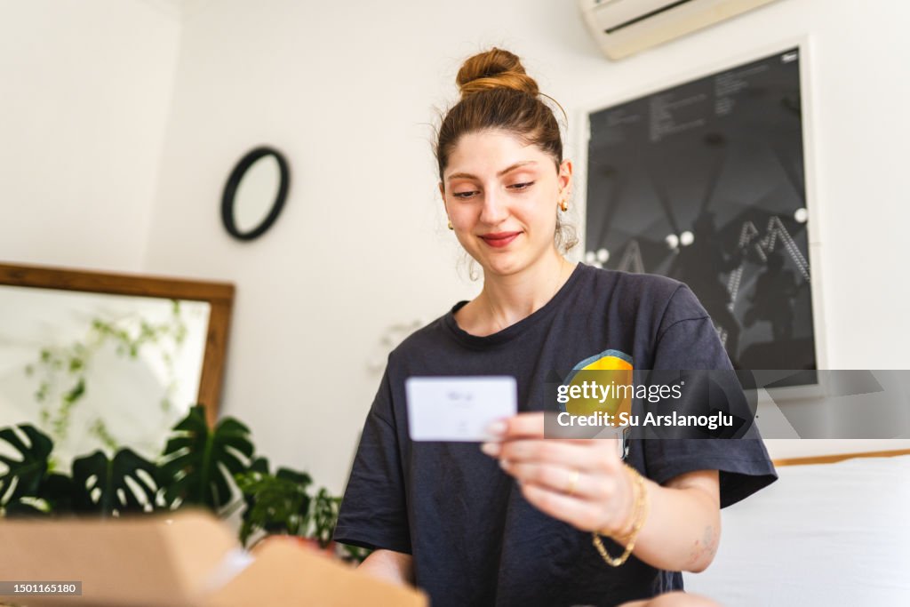 Young woman receiving a gift and reading the note inside