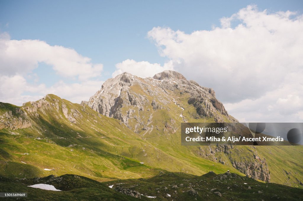 Lush meadow, mountains and snow patches