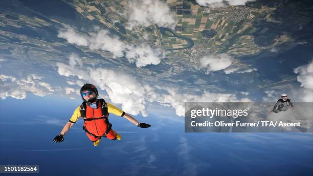 a skydiver soars through the sky - adrenalin stock-fotos und bilder