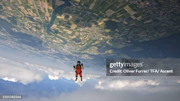 a skydiver soars through the sky - adrenalin stock-fotos und bilder
