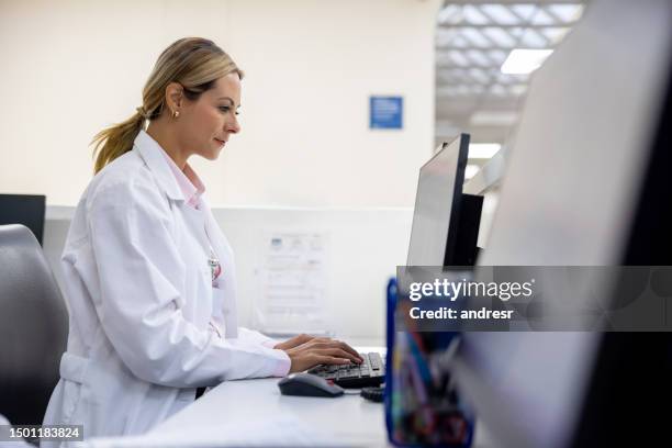 doctor using a computer at the hospital - nurses station stock pictures, royalty-free photos & images