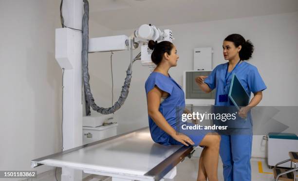 radiologue parlant à un patient dans la salle de radiographie - équipement de radiologie photos et images de collection