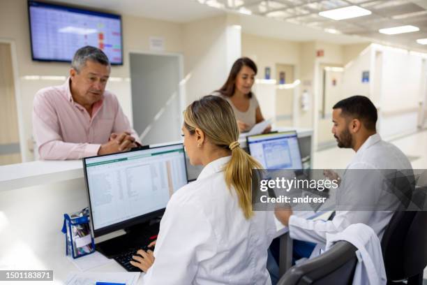 doctors registering patients at the hospital - secretariat stock pictures, royalty-free photos & images