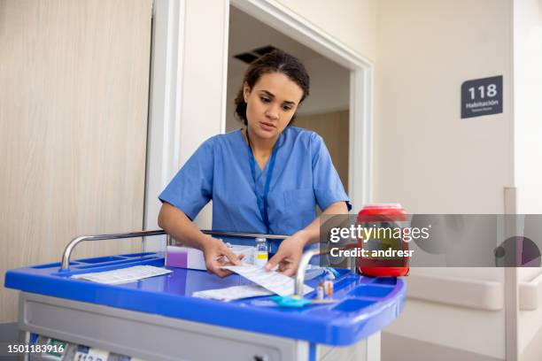 nurse working at the hospital dispensing medicine in the rooms - hospital cart stock pictures, royalty-free photos & images