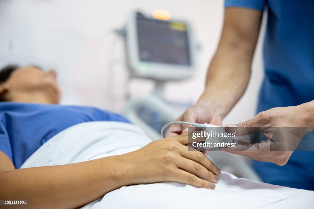 Nurse placing a pulse oximeter on a patient at the hospital