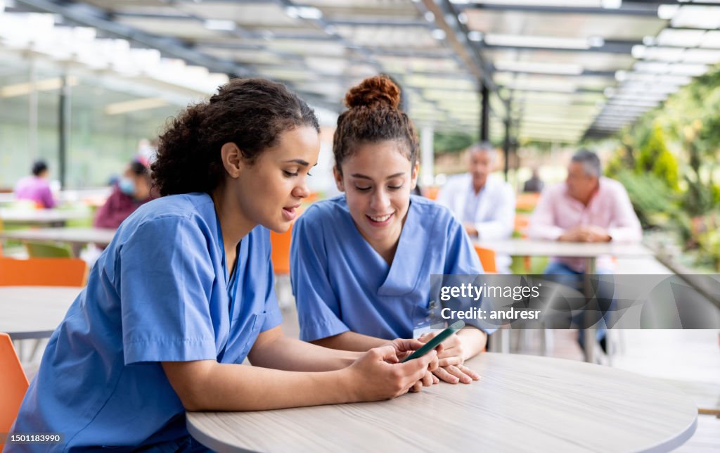 Nurses taking a break and looking at social media at the cafeteria