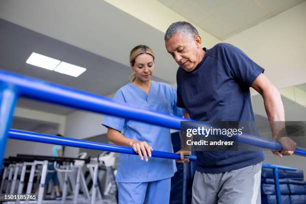 man doing physical therapy and walking on bars - coluna vertebral humana imagens e fotografias de stock