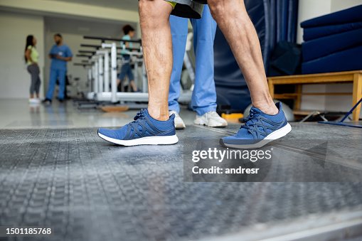 Close-up on a man in physical therapy taking his first steps Close-up on a man in physical therapy taking his first steps