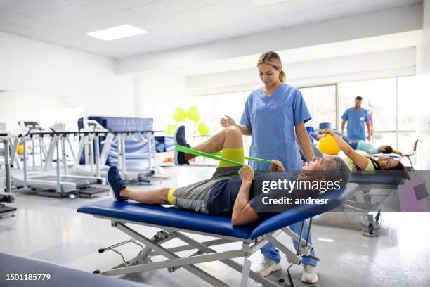 man doing physical therapy exercises using a stretch band - ortopedia imagens e fotografias de stock