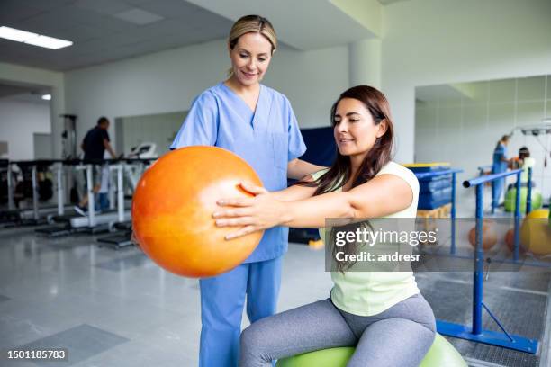 donna che fa esercizi di terapia fisica usando una palla fitness - fisioterapia foto e immagini stock