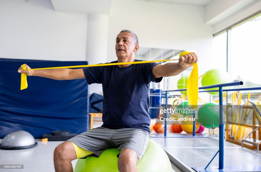 Man doing physiotherapy exercises using a stretch band