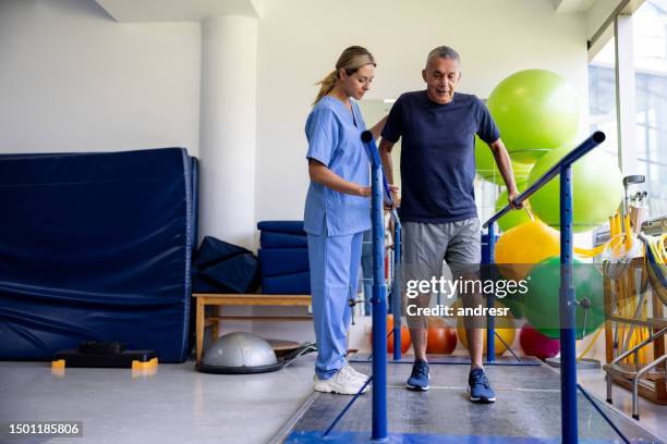 man in physical therapy walking on bars - gymnastics bar stock pictures, royalty-free photos & images