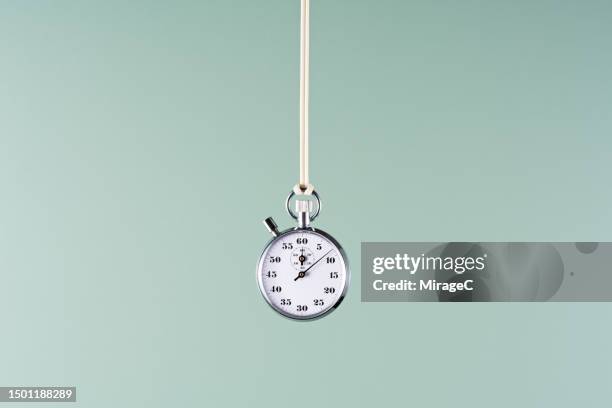 stopwatch hanging on green background - stop watch stock pictures, royalty-free photos & images