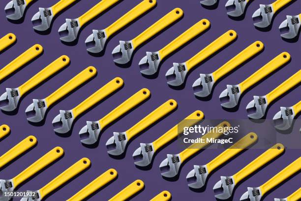 yellow adjustable wrench repetition pattern - fe symbol stock pictures, royalty-free photos & images