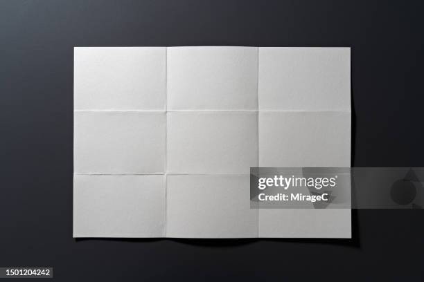 unfolded paper sheet on black background - plie photos et images de collection