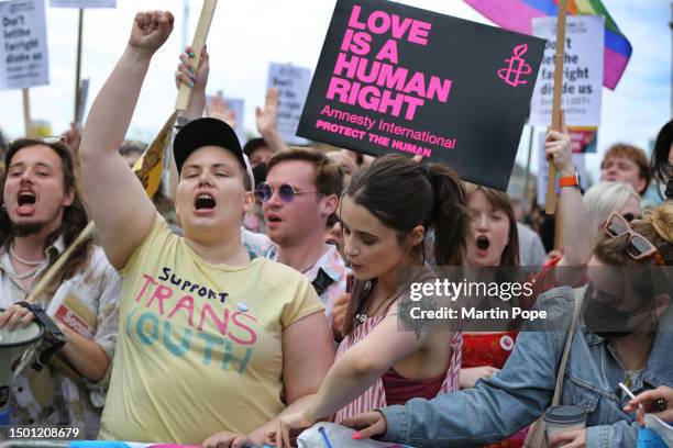 Supporters of the drag queen show shout their point of view at counter protesters from behind a police cordon, holding signs that support their...