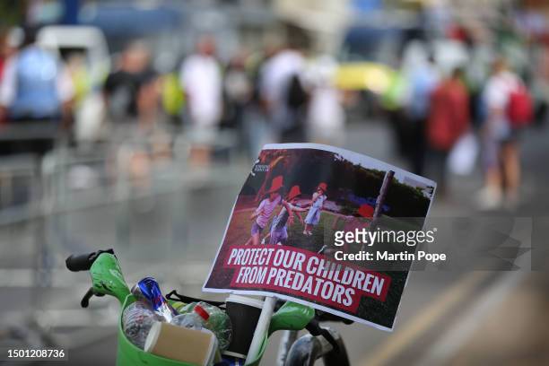 Sign which reads 'protect our children from predators' is left in the basket of a bicycle on June 24, 2023 in London. Protesters in support and...